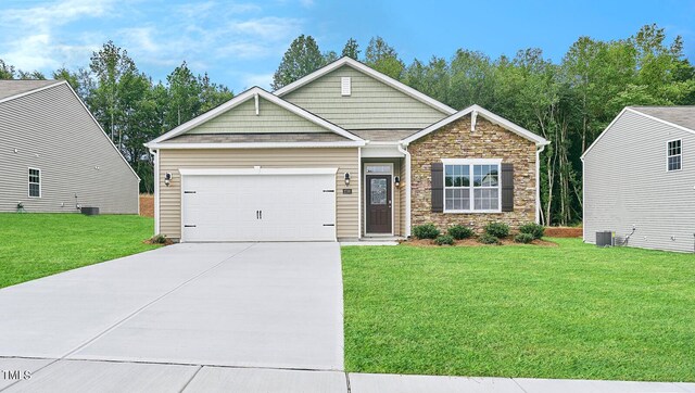 craftsman-style home featuring cooling unit, a garage, and a front yard