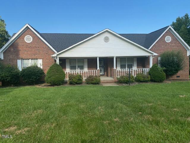 view of front of house with covered porch and a front lawn