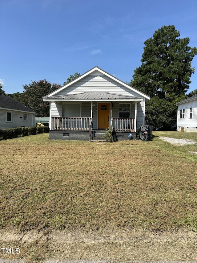 bungalow with covered porch and a front lawn