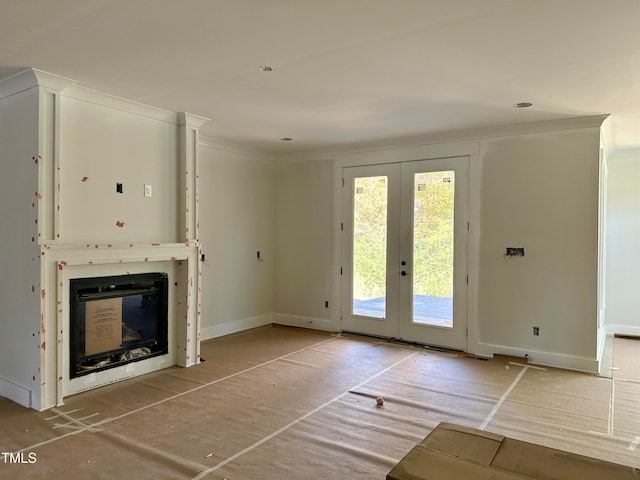 unfurnished living room featuring crown molding and french doors