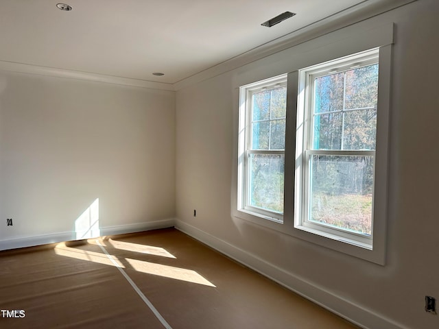 unfurnished room with ornamental molding and a healthy amount of sunlight