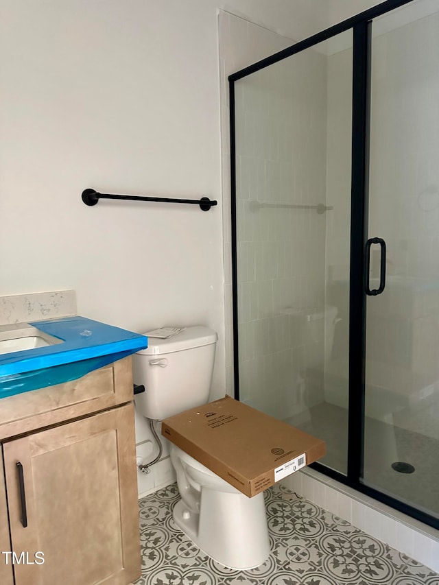 bathroom with tile patterned flooring, toilet, vanity, and walk in shower