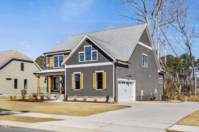 view of front facade with central AC unit, concrete driveway, roof with shingles, an attached garage, and a front yard