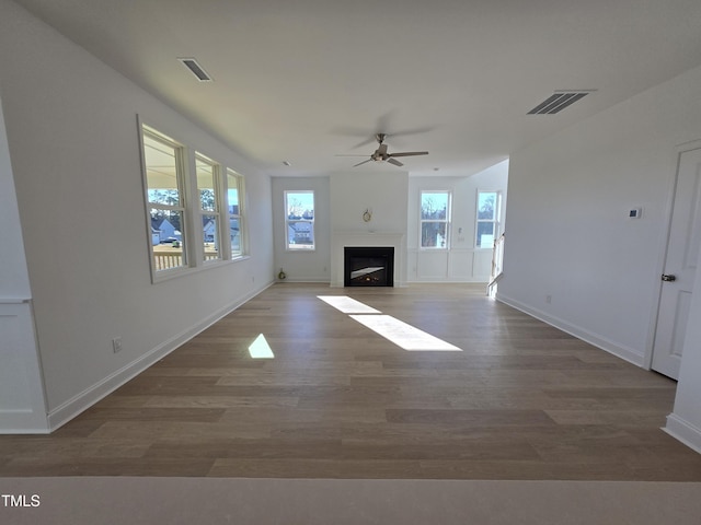 unfurnished living room with ceiling fan and hardwood / wood-style floors