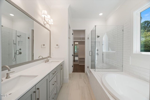 bathroom with vanity, shower with separate bathtub, and crown molding