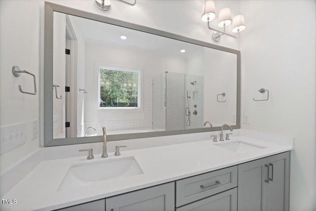 bathroom with vanity, a shower with shower door, and ornamental molding