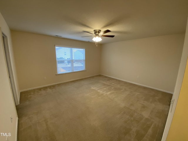 carpeted empty room featuring ceiling fan