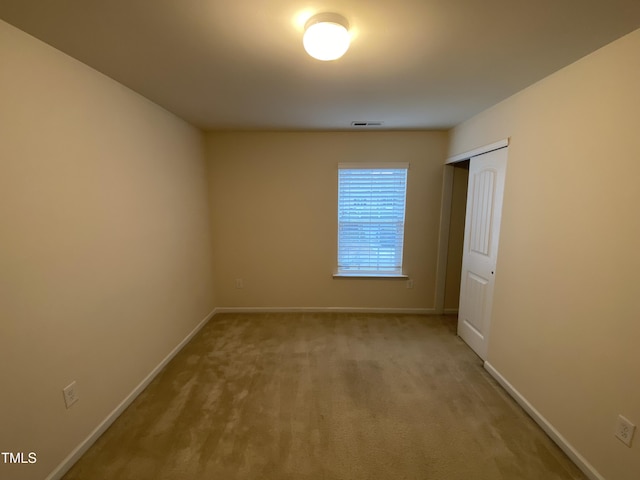 spare room featuring light carpet