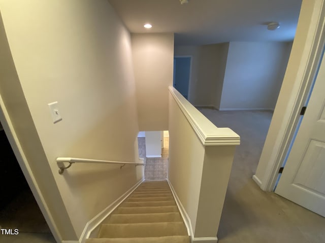 stairway featuring carpet flooring