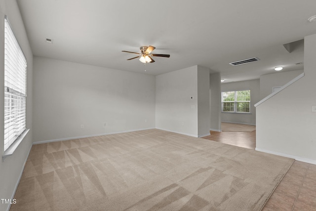 carpeted spare room featuring ceiling fan