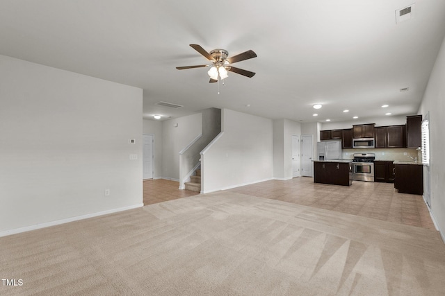 unfurnished living room featuring light colored carpet and ceiling fan