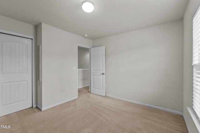 unfurnished bedroom with a closet and light carpet