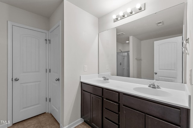 bathroom with an enclosed shower, vanity, and tile patterned floors