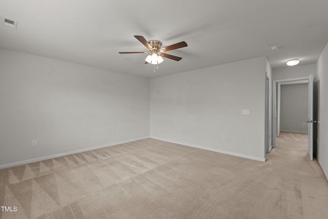 spare room featuring light carpet and ceiling fan