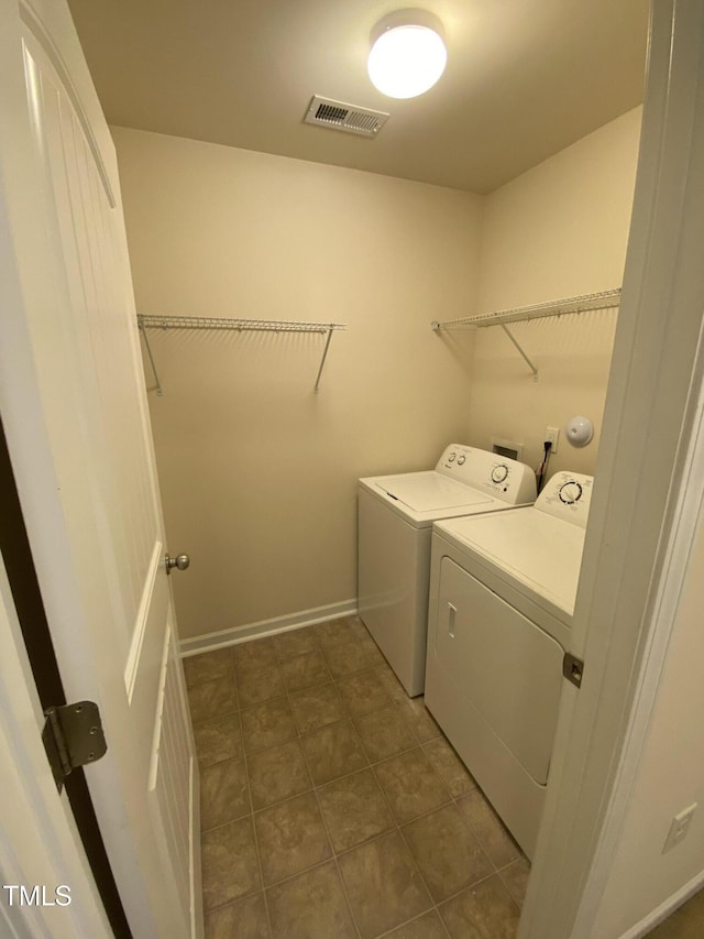 laundry room featuring dark tile patterned floors and separate washer and dryer