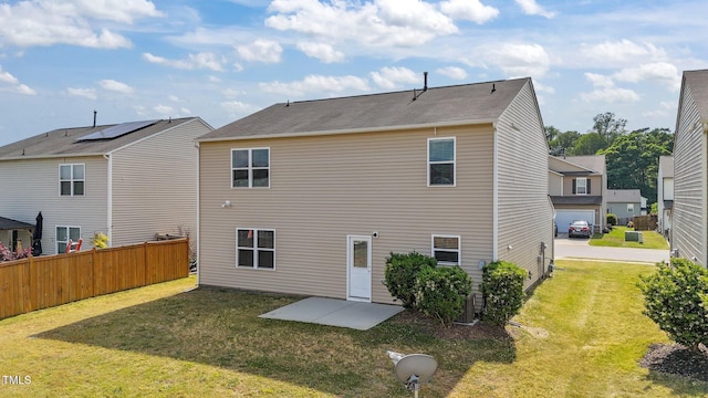 rear view of property featuring a patio, fence, and a yard