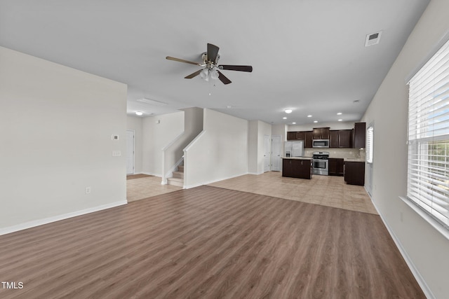 unfurnished living room with visible vents, stairs, ceiling fan, recessed lighting, and light wood-type flooring