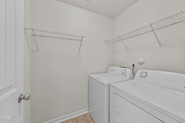 washroom with baseboards, laundry area, light tile patterned flooring, and washer and dryer