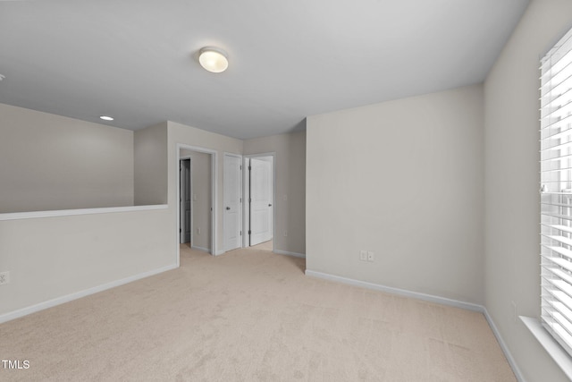 carpeted empty room featuring baseboards
