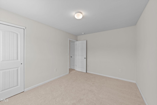 unfurnished bedroom featuring baseboards and light colored carpet