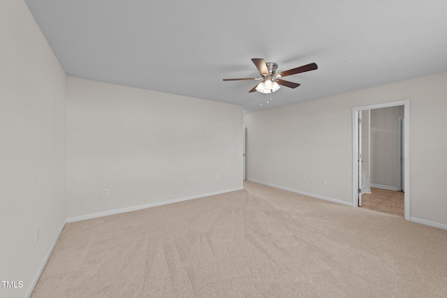 empty room featuring baseboards, ceiling fan, and light carpet