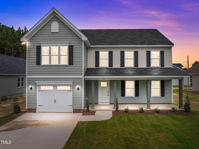 view of front of home featuring a garage, a lawn, and covered porch