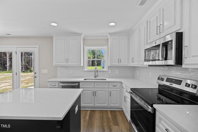 kitchen featuring tasteful backsplash, sink, plenty of natural light, stainless steel appliances, and white cabinets