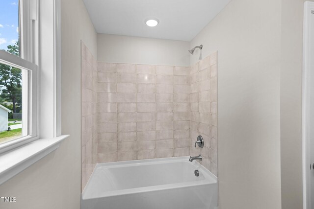 bathroom featuring plenty of natural light and tiled shower / bath