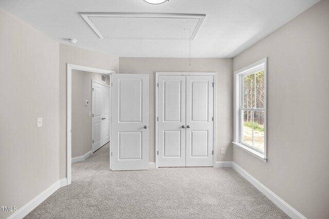 unfurnished bedroom featuring a closet and light carpet