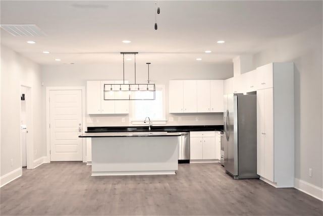 kitchen with sink, light hardwood / wood-style floors, white cabinetry, stainless steel appliances, and pendant lighting