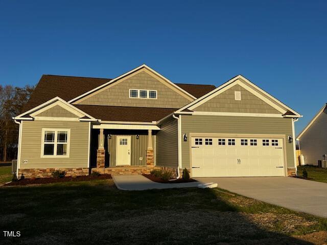 craftsman house featuring a front yard and a garage