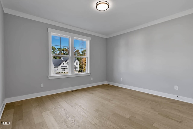 spare room featuring light hardwood / wood-style flooring and crown molding