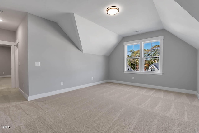 additional living space with light colored carpet and lofted ceiling