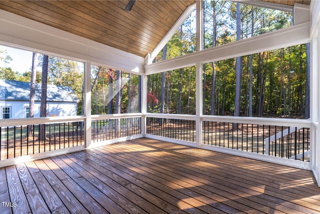 unfurnished sunroom featuring wood ceiling, a healthy amount of sunlight, and vaulted ceiling