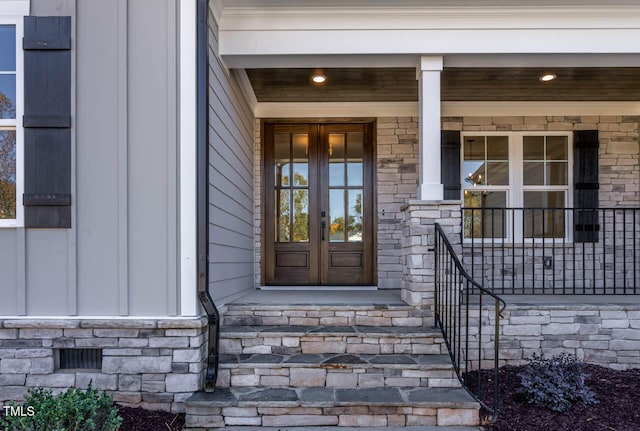 view of exterior entry with covered porch and french doors