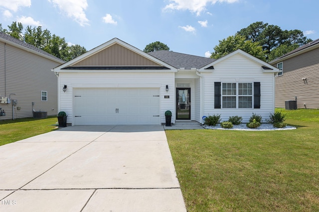 ranch-style home featuring a garage, cooling unit, and a front yard