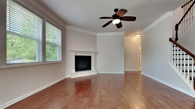 unfurnished living room with ceiling fan, wood-type flooring, and ornamental molding