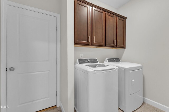 washroom with cabinets, light tile patterned flooring, and independent washer and dryer