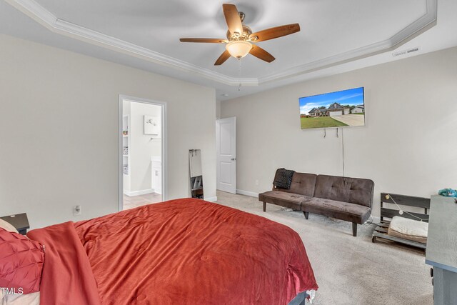 bedroom featuring light carpet, a tray ceiling, ceiling fan, and ensuite bathroom