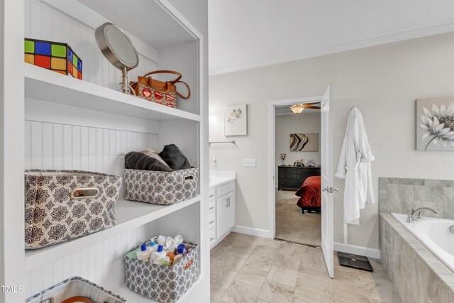 interior space with vanity, ornamental molding, tiled bath, and tile patterned flooring