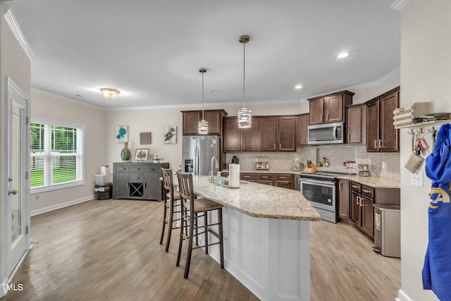 kitchen featuring crown molding, stainless steel appliances, light hardwood / wood-style flooring, and decorative backsplash