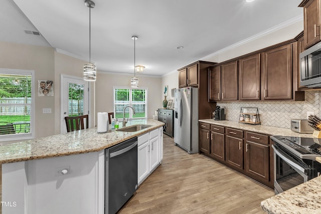 kitchen with stainless steel appliances, sink, backsplash, light hardwood / wood-style flooring, and decorative light fixtures