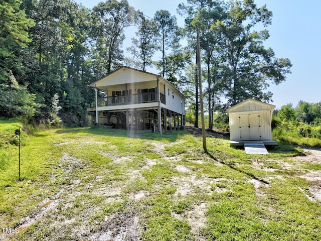 back of house with a storage shed