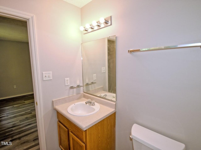 bathroom with toilet, vanity, and hardwood / wood-style flooring