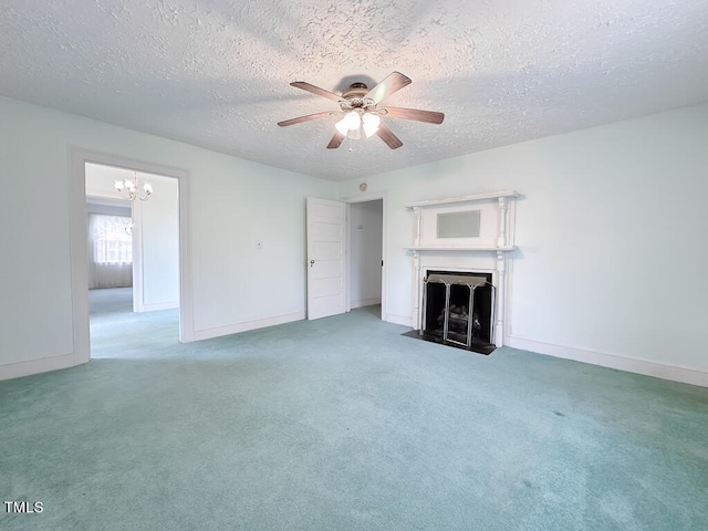 unfurnished living room featuring ceiling fan with notable chandelier, a textured ceiling, and carpet