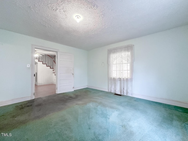 unfurnished room with a textured ceiling and carpet floors