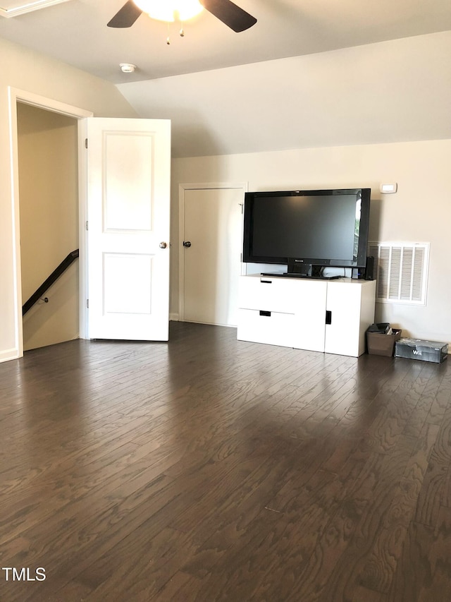 unfurnished living room featuring dark wood-type flooring and ceiling fan