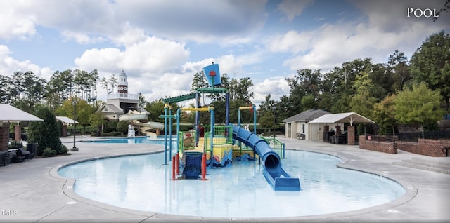 view of pool featuring a playground, a water slide, and a patio area