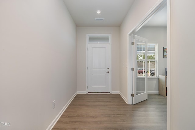 interior space with wood finished floors, visible vents, and baseboards