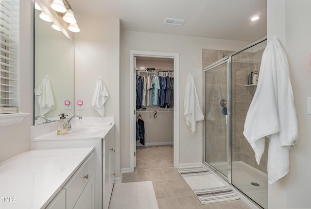 full bath with a stall shower, visible vents, tile patterned flooring, a spacious closet, and vanity